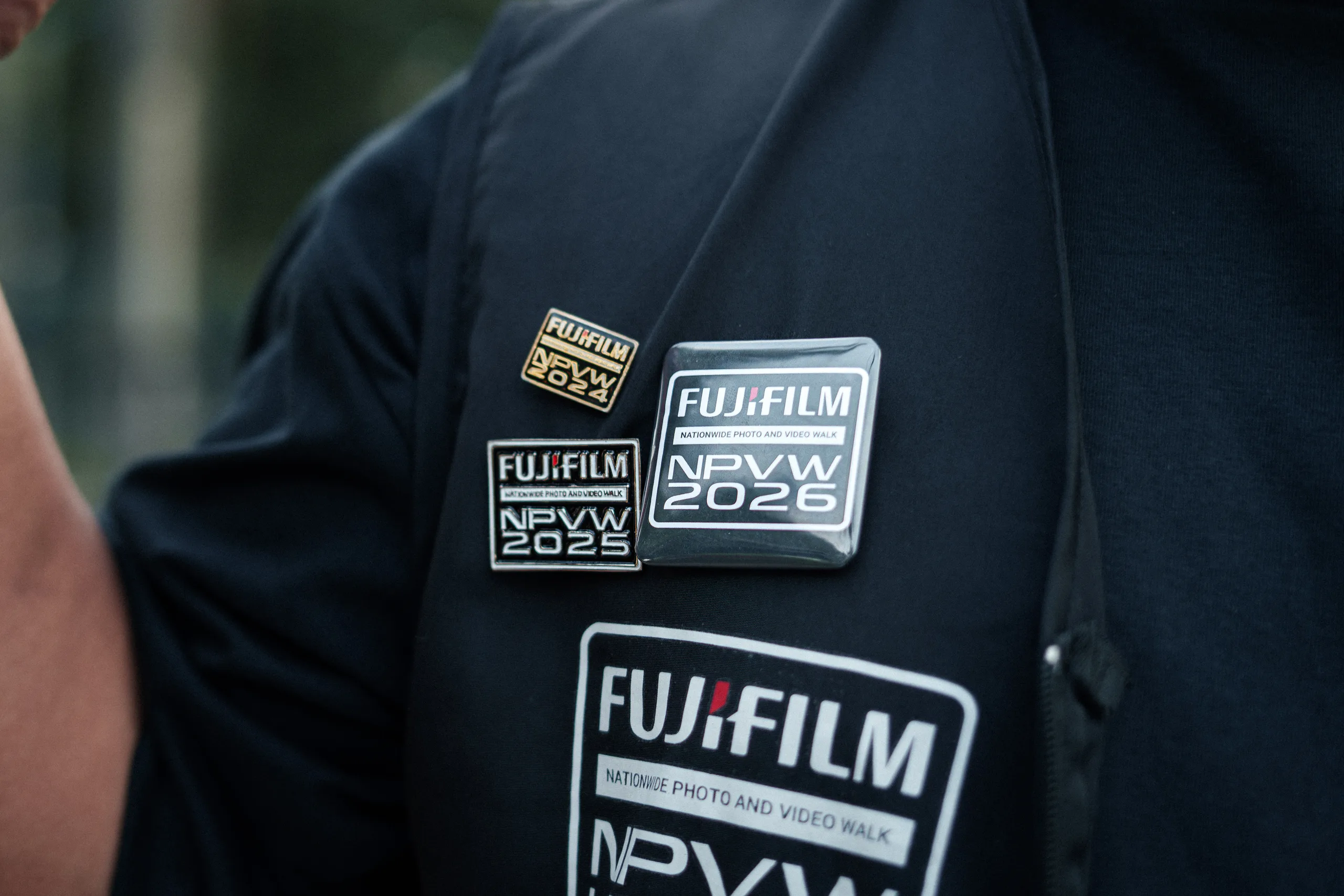 Fujifilm Nationwide Photo and Video Walk 2026 badges pinned to a black event shirt.